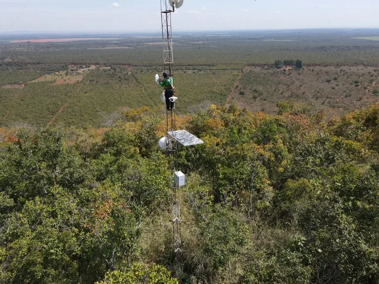 Torre rural com antenas e painel de energia solar em ponto estratégico