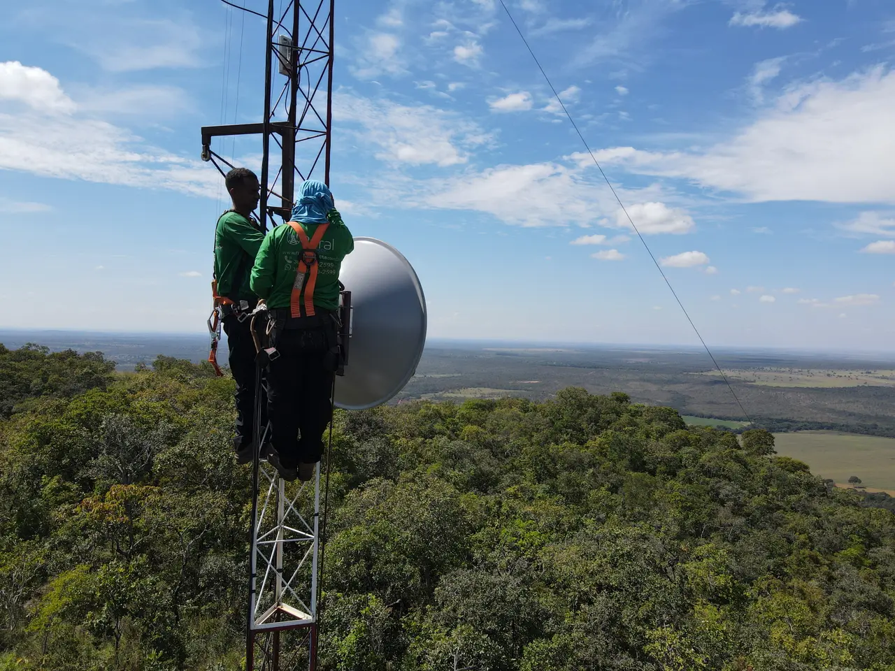 Técnicos da Rural Conecta trabalhando em uma torre de telecomunicações no campo